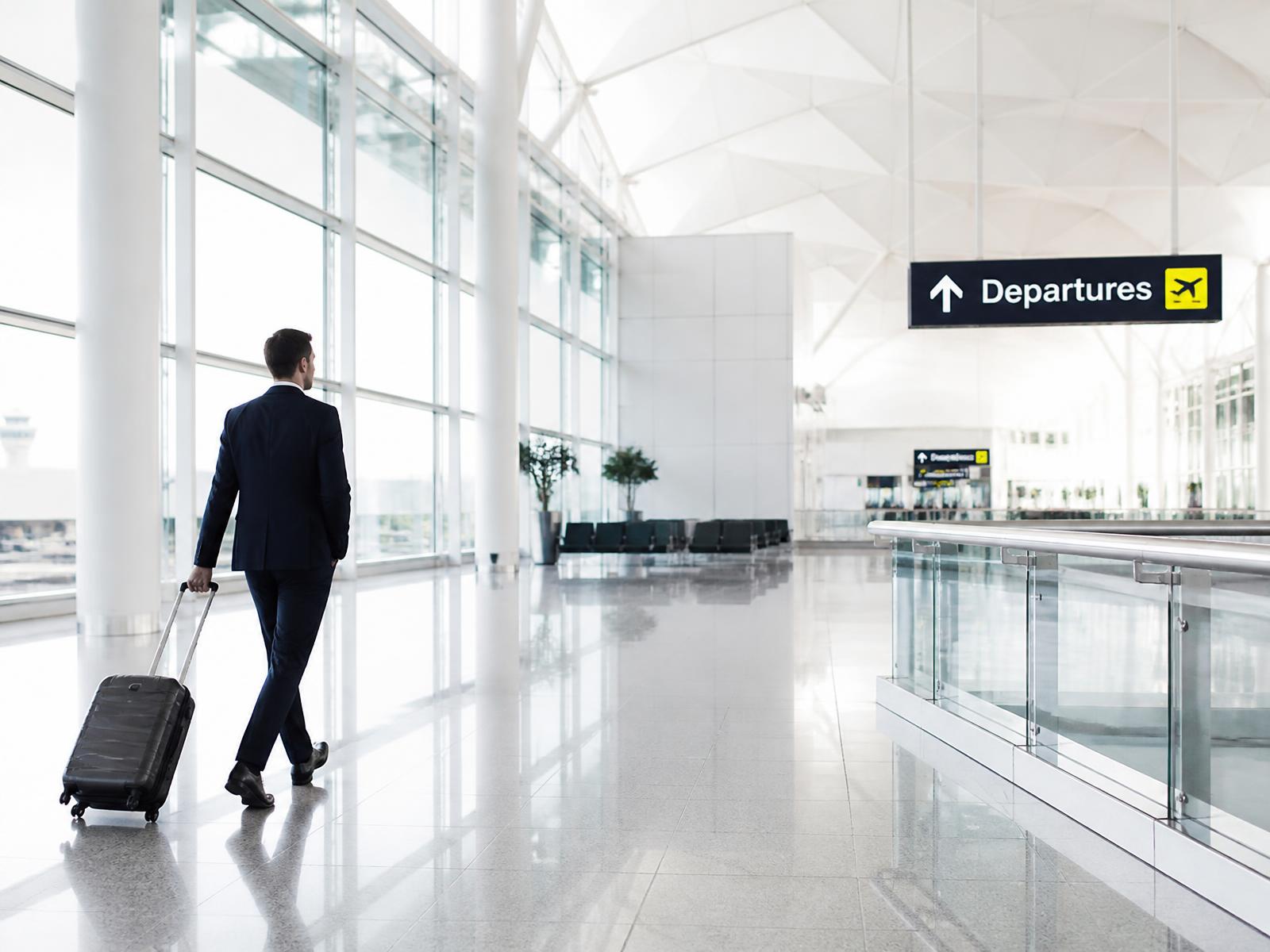 Business traveller walking through a bright airport departure hall